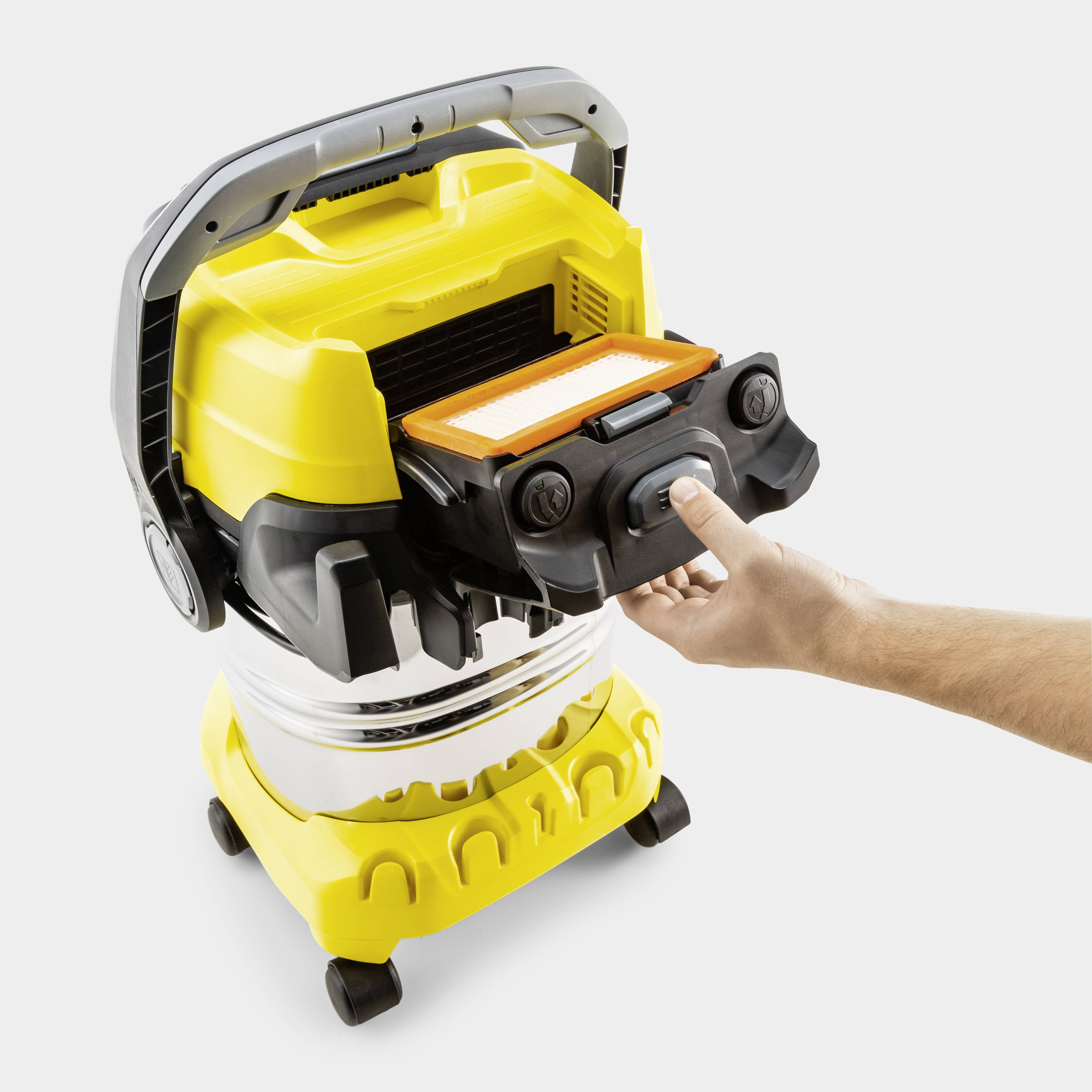 Ein gelbes, tragbares Gerät mit integriertem Filter wird von einer Hand bedient, möglicherweise ein Staubsauger.