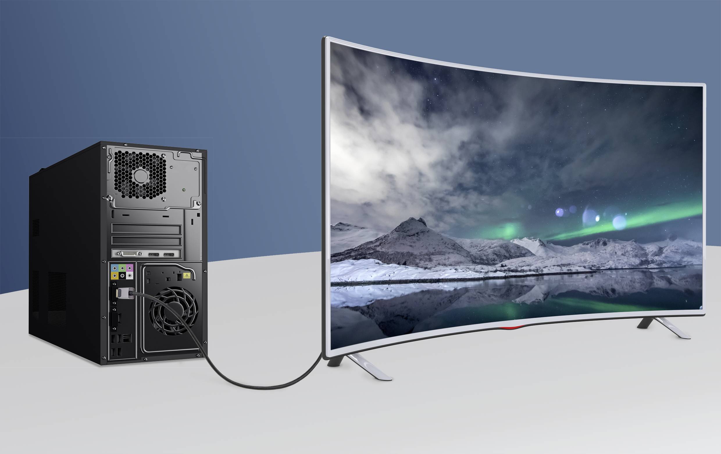 Ein Desktop-Computer ist mit einem gebogenen Monitor verbunden, der ein Bild von schneebedeckten Bergen unter dem Nachthimmel zeigt.