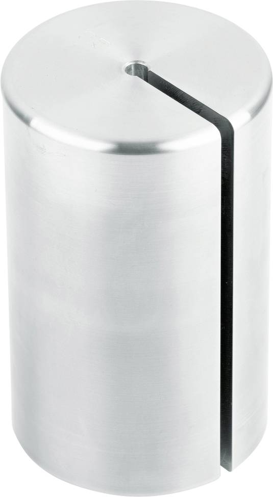 Ein zylinderförmiger Metallblock mit einem schmalen Schlitz von oben nach unten, vermutlich ein Teil eines Werkzeugs oder einer Maschine.