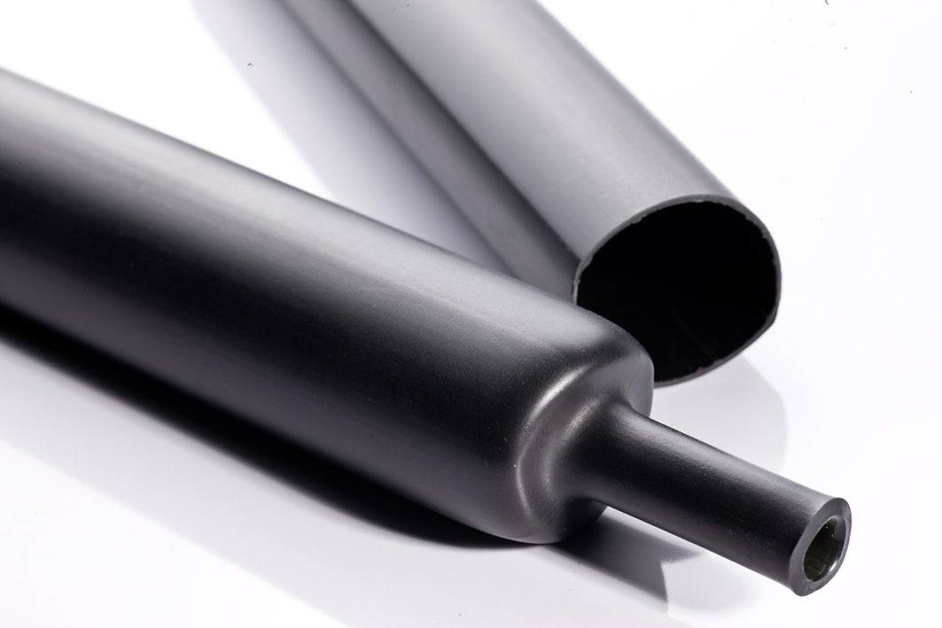 Zwei schwarze Rohre liegen nebeneinander. Eines der Rohre ist am Ende offen, das andere hat eine flachen Verschluss.