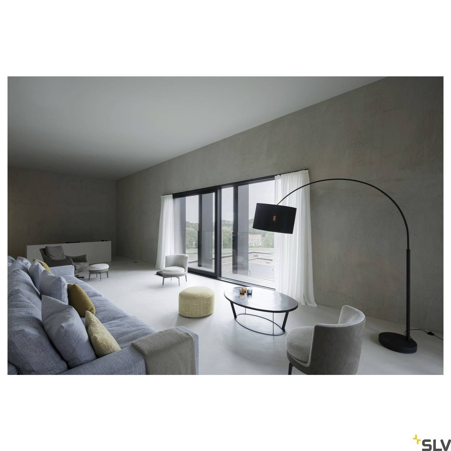 Ein modernes Wohnzimmer mit grauem Sofa, hellem Teppich, großen Fenstern, die viel Licht hereinlassen, und einem eleganten Lampenbogen.