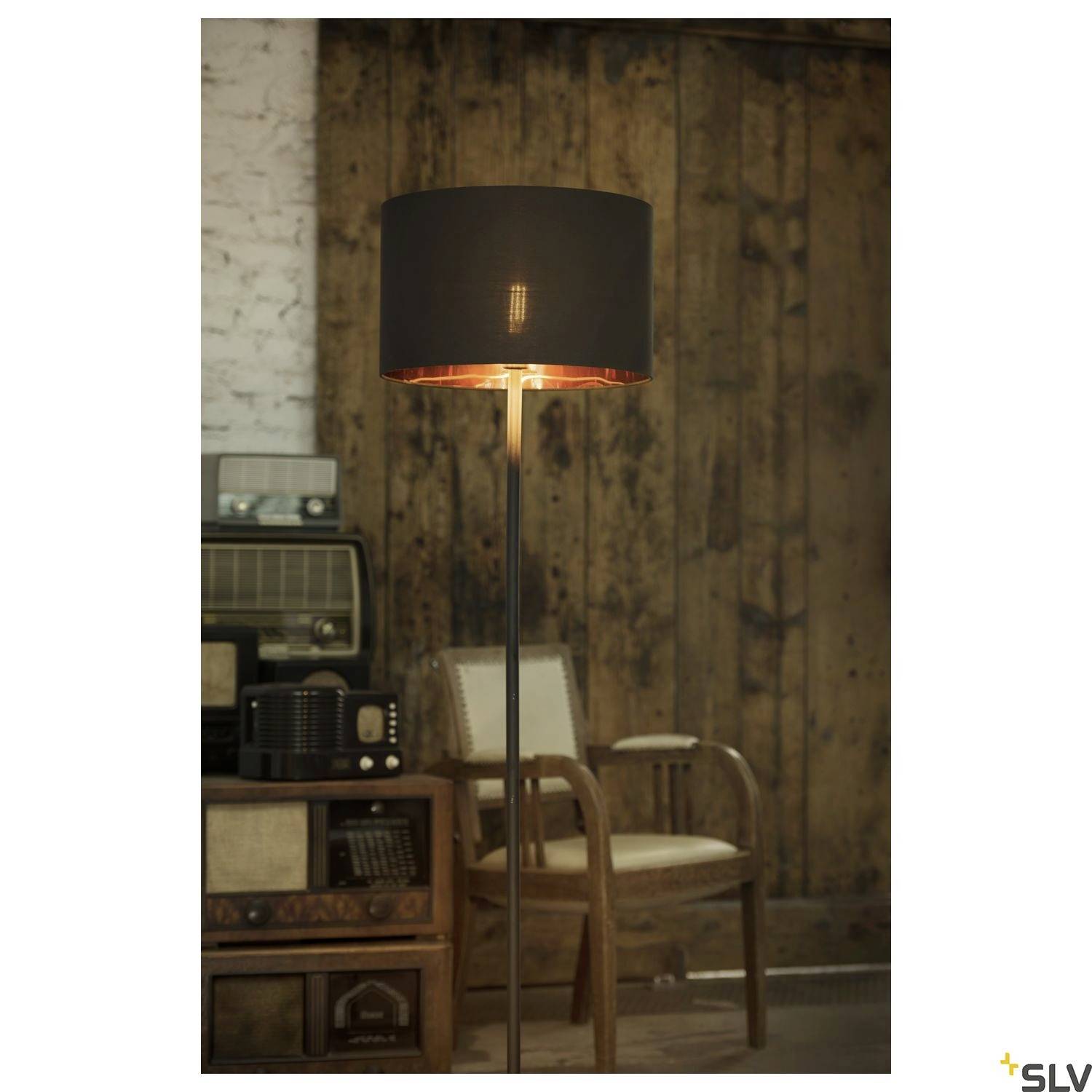 Stehlampe mit schwarzem Lampenschirm in vintage eingerichteter Umgebung, Holzstuhl im Hintergrund, retro Radio und Dekor.