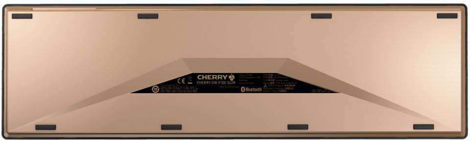 Rückseite einer Tastatur in Metalloptik. Zeigt verschiedene Schrauben und Aufdrucke, einschließlich des Wortes 'CHERRY'.