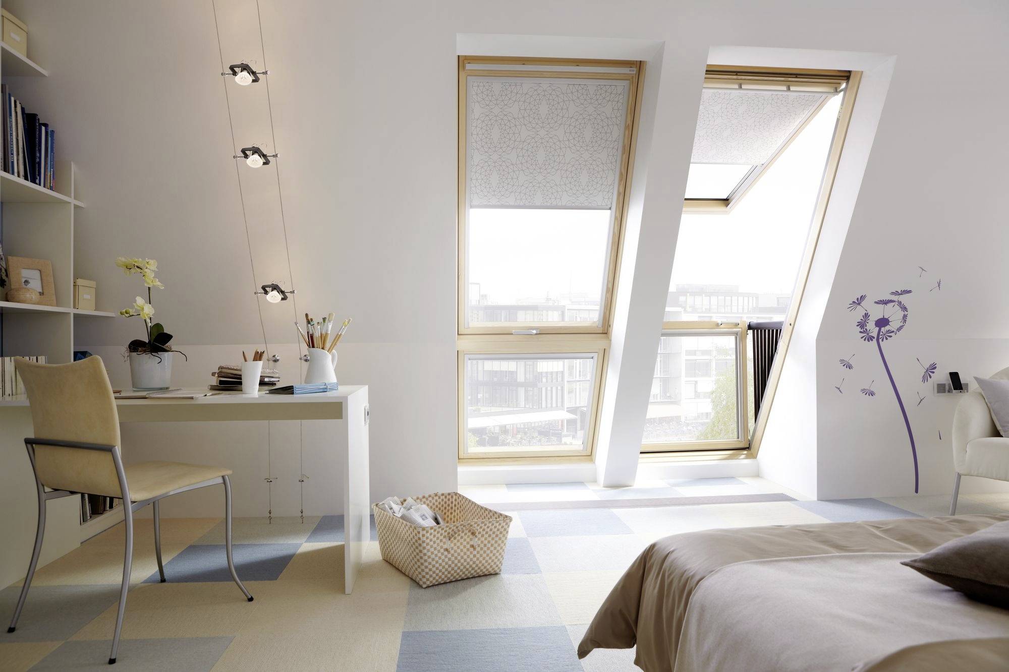Helles Schlafzimmer mit Dachfenster, Schreibtisch mit Stuhl, Bett und Regalen; ein Korb steht auf dem Boden.
