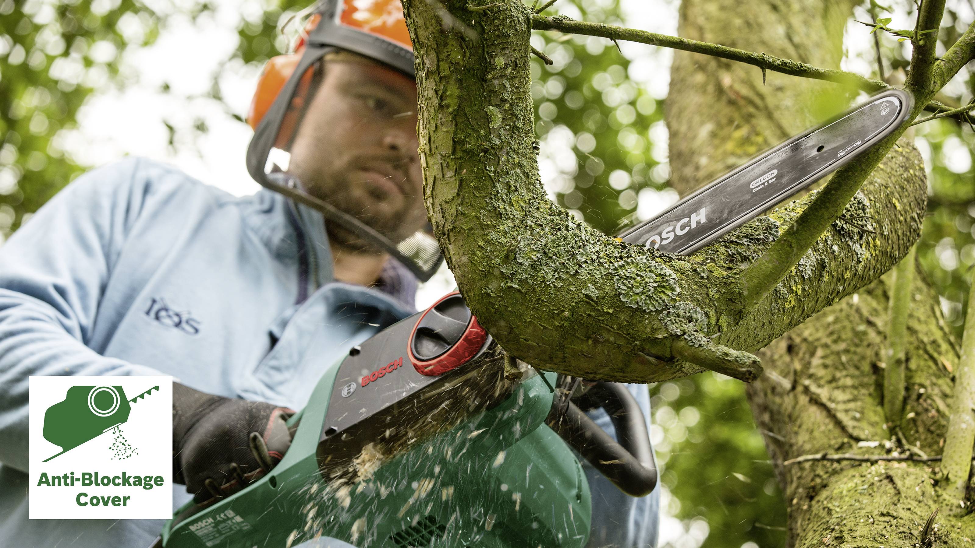 Ein Person sägt mit einer Motorsäge einen dicken Ast von einem Baum. Ein Logo in der Ecke zeigt 'Anti-Blockage Cover'.