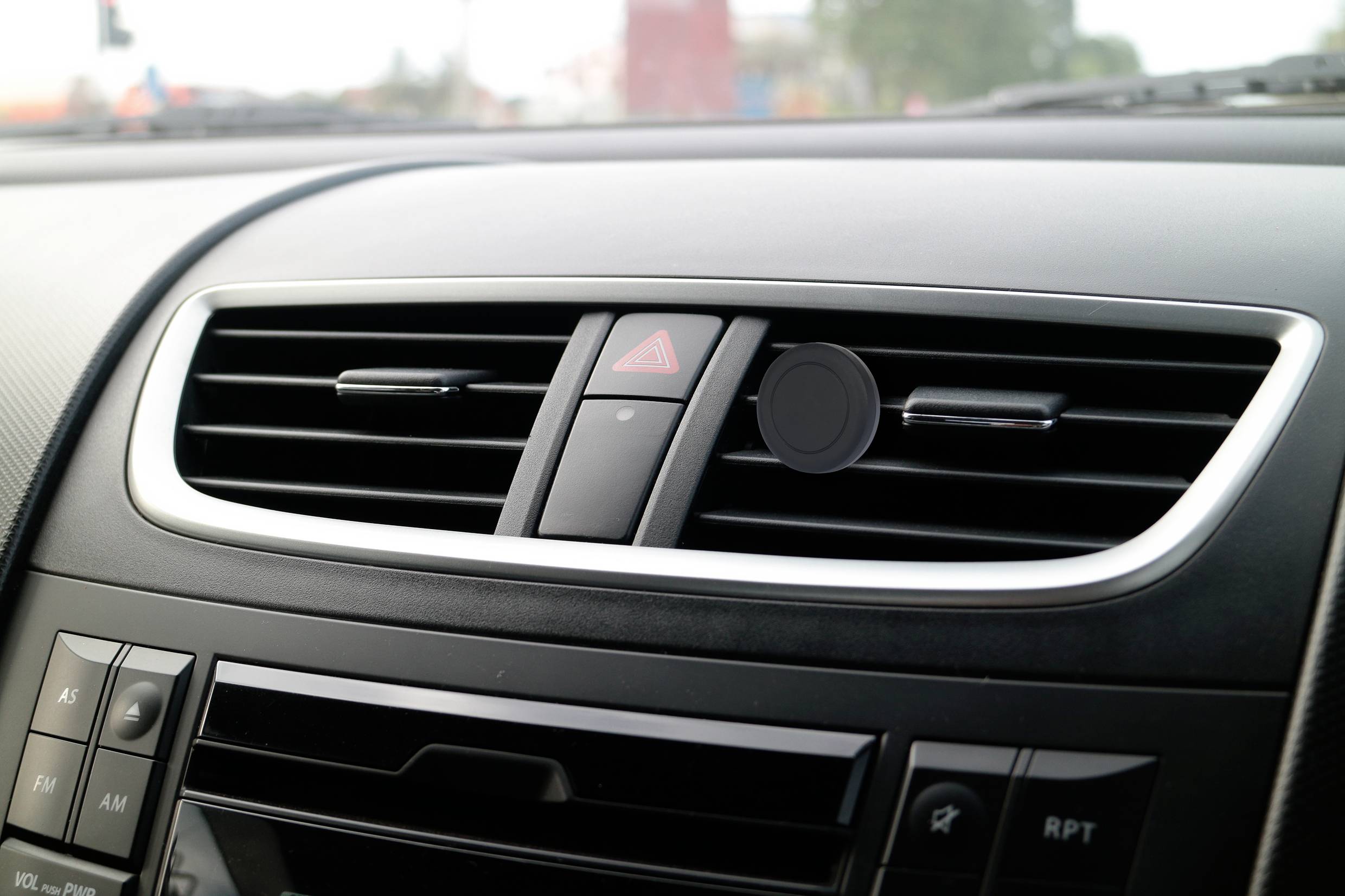 Lüftungsschlitze auf dem Armaturenbrett eines Autos, Knöpfe für Klimaanlage und Warnblinklicht zwischen den Schlitzen.