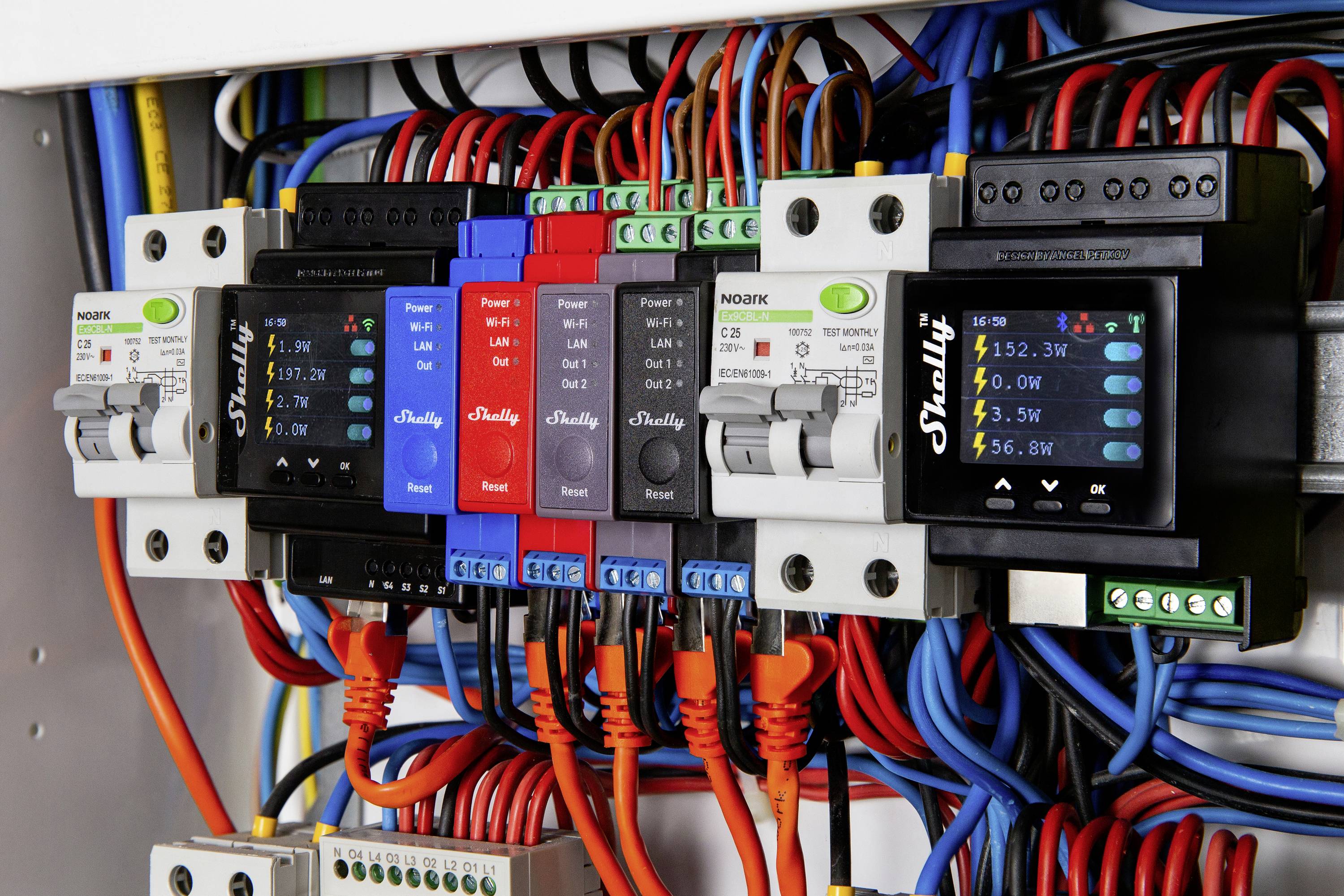 Elektrischer Schaltschrank mit mehreren digitalen Messgeräten und bunten Kabeln, die Stromspannungen und Stromstärken anzeigen.