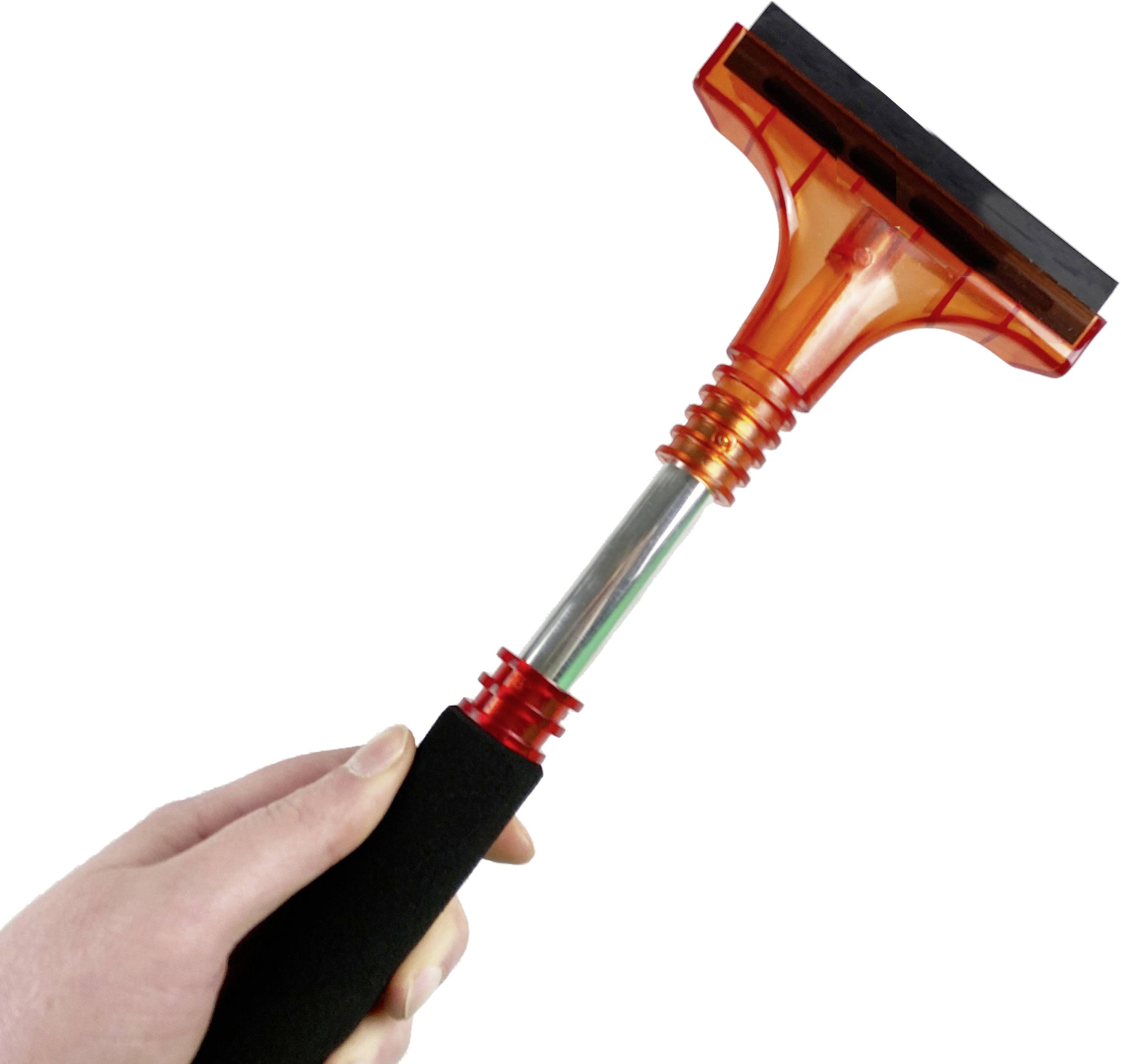 Eine Hand hält einen Eiskratzer mit einem schwarzen Griff und einem orangefarbenen Kopf.