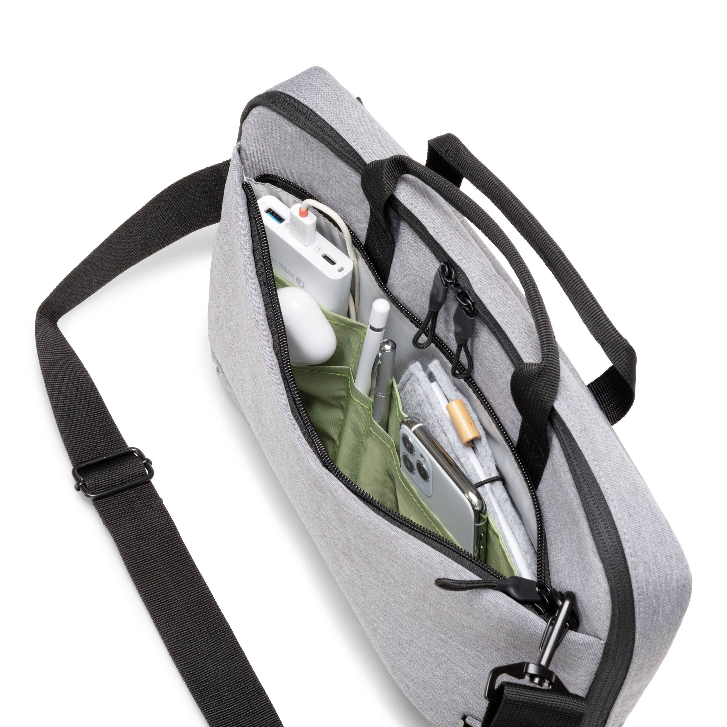 Graue Umhängetasche mit geöffneter Reißverschlusstasche, sichtbar sind ein Smartphone, Kopfhörer, ein Ladegerät und ein Kugelschreiber.