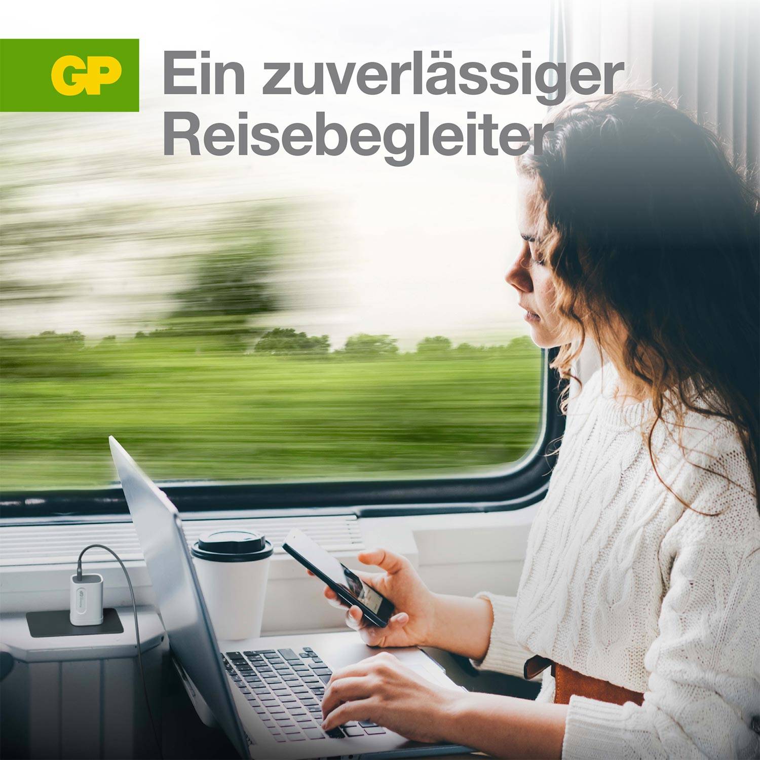 Frau in Kleidung mit Laptop und Smartphone in einem Zug, umweltfreundliches Reisen symbolisierend. Text 'Ein zuverlässiger Reisebegleiter'.