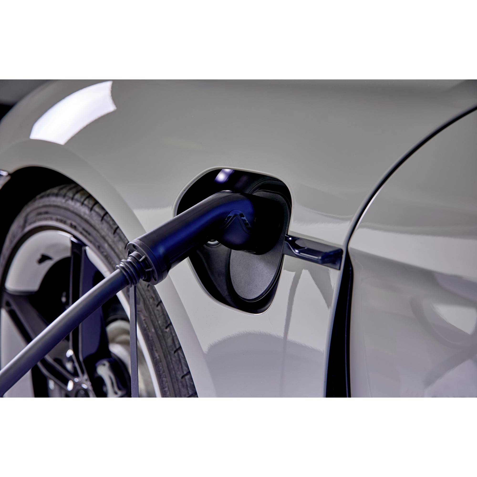 Ein Elektroauto wird aufgeladen, Ladekabel ist mit der Steckdose des Fahrzeugs verbunden. Hauptfokus auf nachhaltige Mobilität.