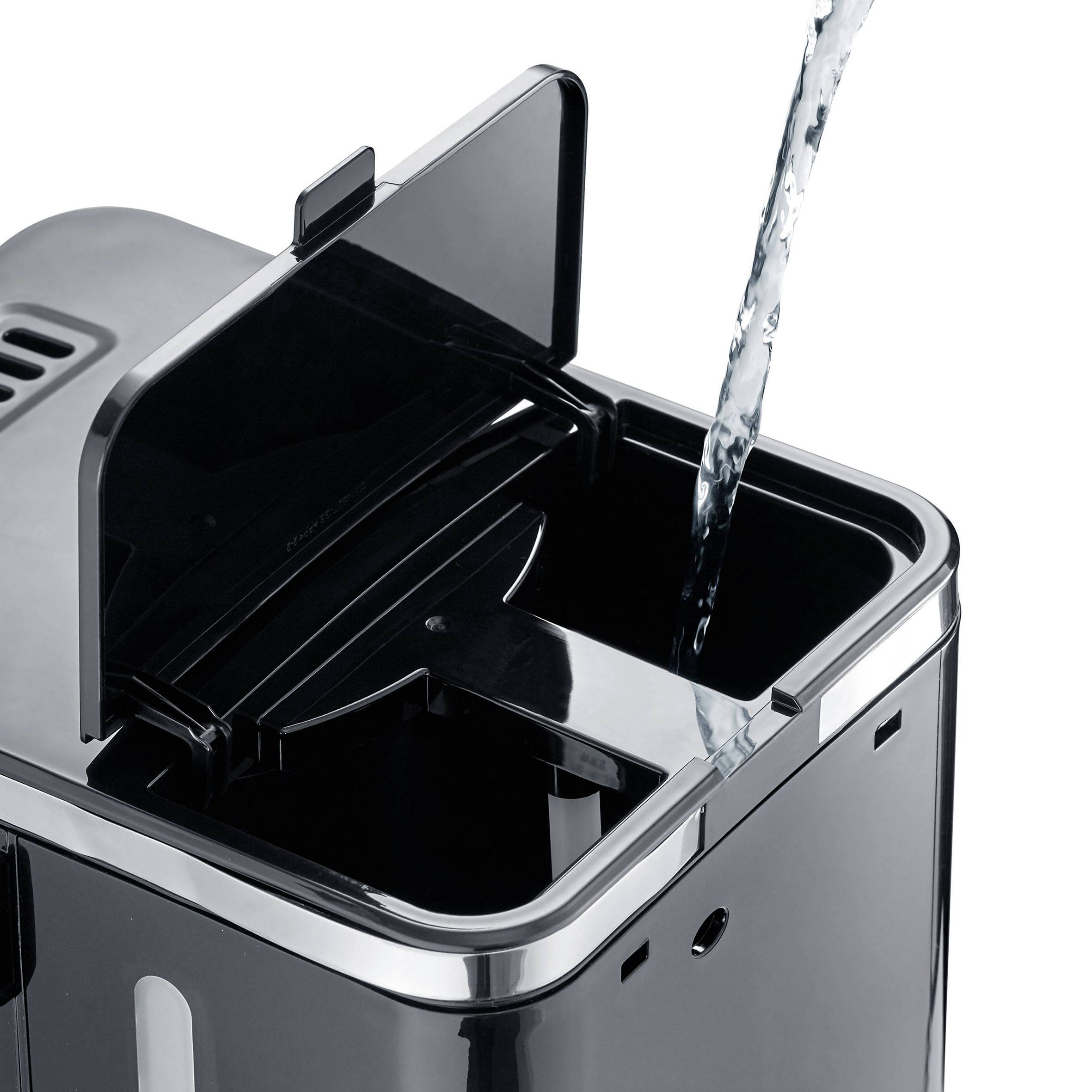 Ein Wasserstrahl wird in einen offenen schwarzen Luftbefeuchter gegossen.