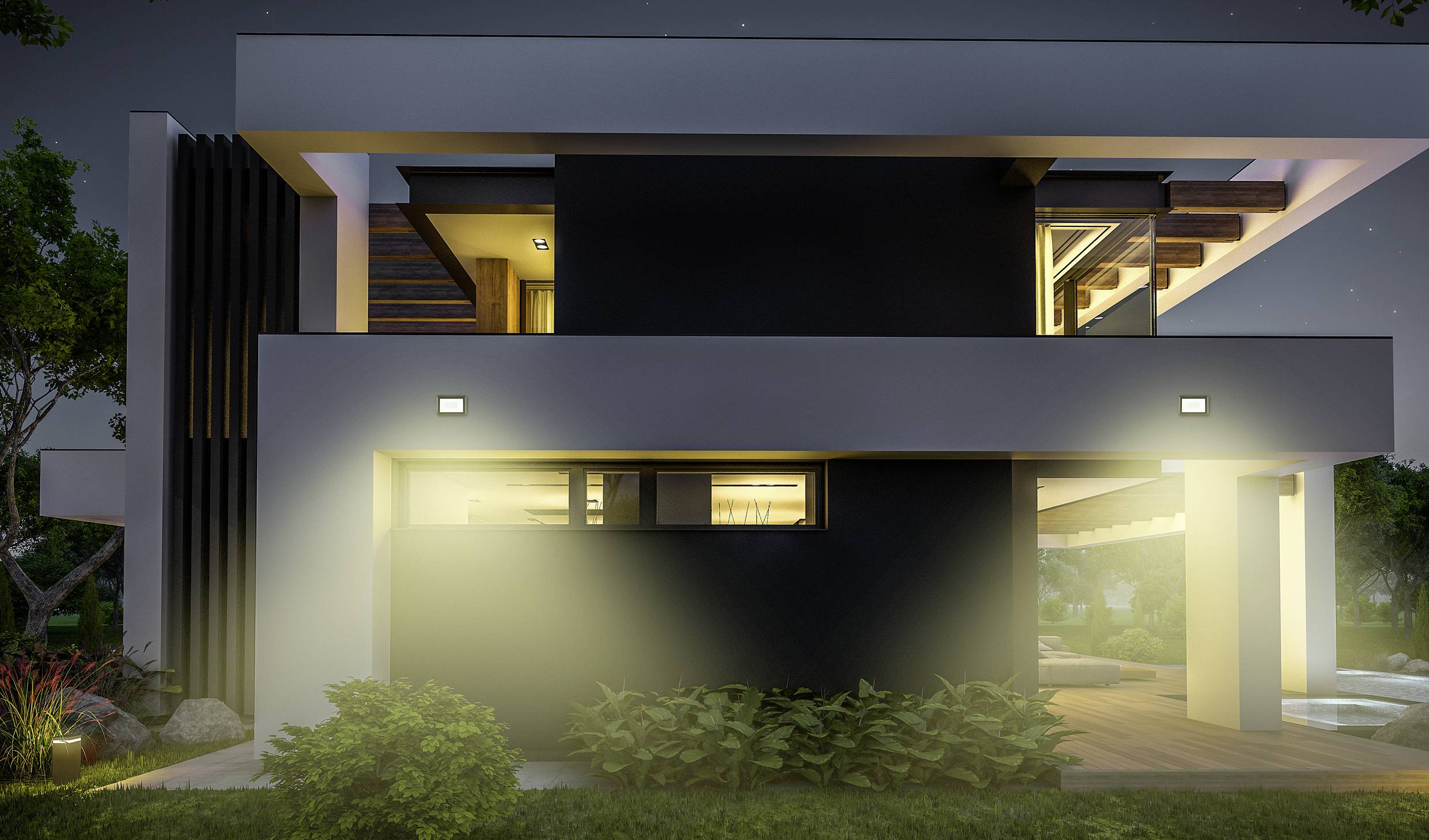 Moderne, zweistöckige Villa mit großen Glasfenstern, beleuchtet in der Nacht. Umgeben von Natur, mit schlichter, stilvoller Architektur.