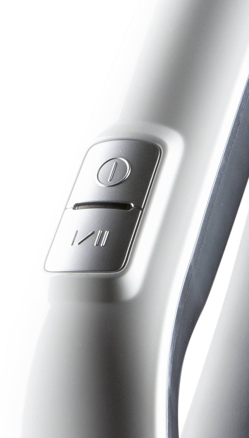 Silberner Knopf mit Einschaltsymbol auf weißem Hintergrund, möglicherweise Teil eines elektronischen Geräts.