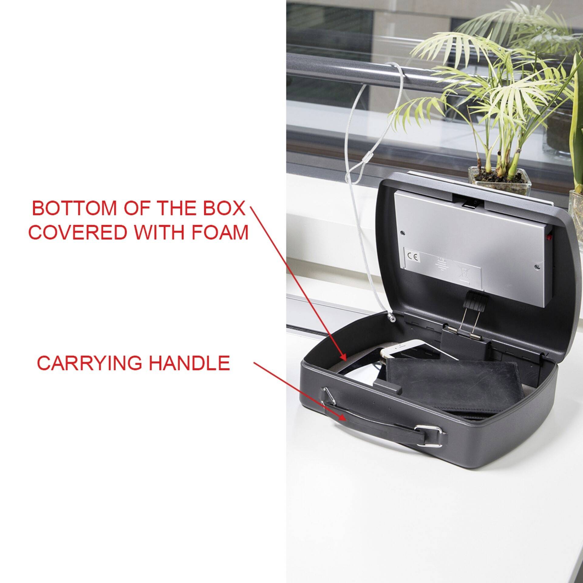 Ein offener Koffer zeigt Schaumstoff im Inneren und einen Tragegriff. Ein Pfeil zeigt auf 'BOTTOM OF THE BOX COVERED WITH FOAM'.