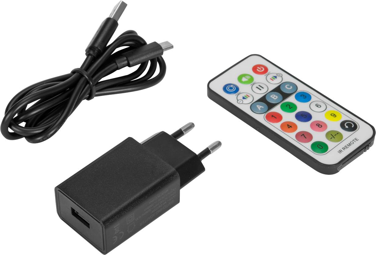 Ein USB-Ladegerät, ein schwarzes USB-Kabel und eine Fernbedienung mit farbigen Tasten liegen auf einer weißen Oberfläche.