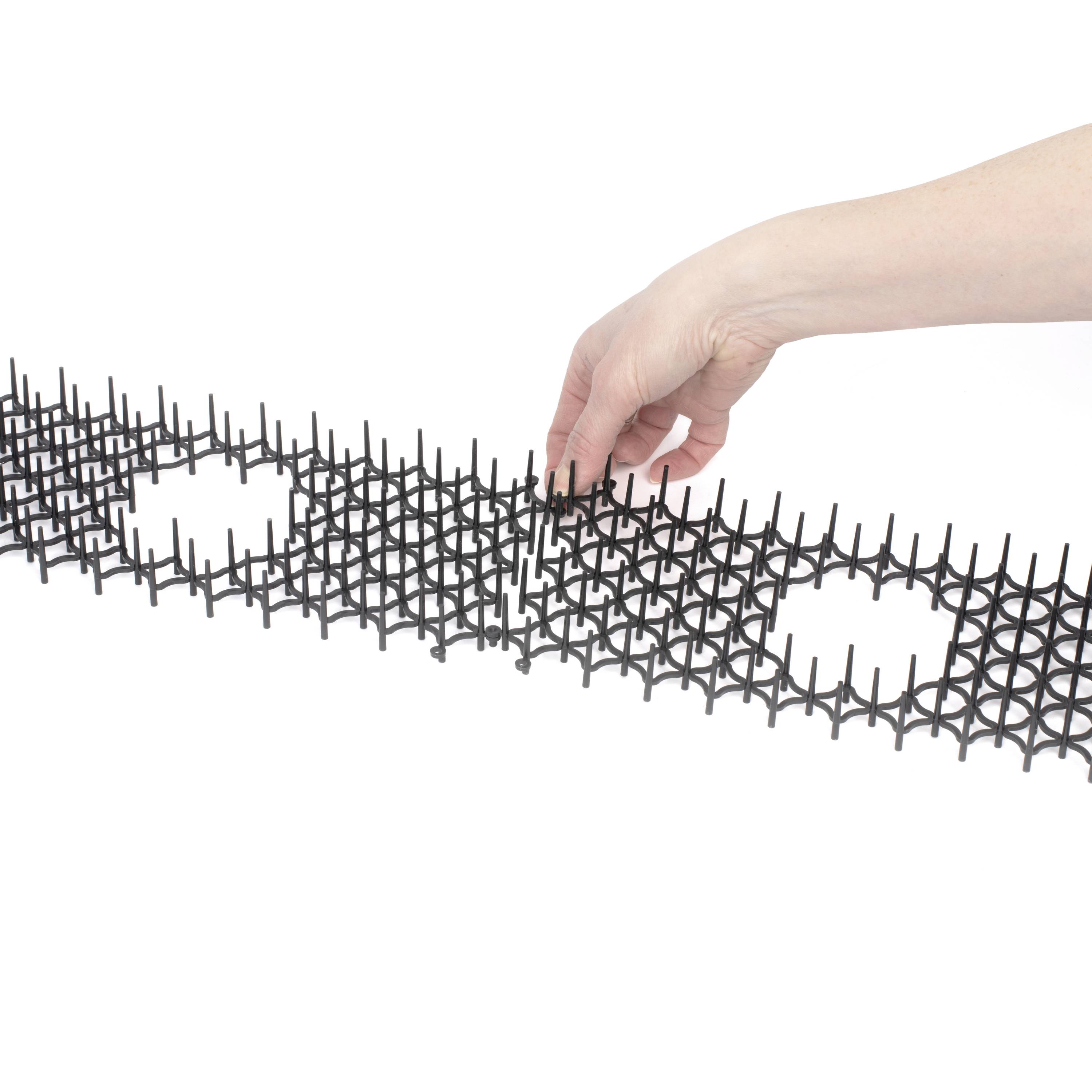 Hand justiert schwarze, gitterförmige Struktur mit runden Aussparungen auf weißem Hintergrund.