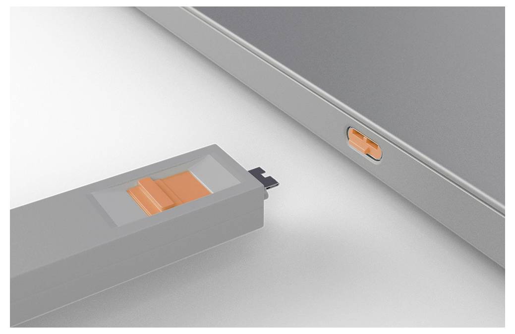 Nahaufnahme eines grauen Geräts und eines passenden Moduls mit orangefarbener Verriegelung, das zeigt, wie das Modul in den Geräte-Schacht eingeführt oder ausgerichtet wird.