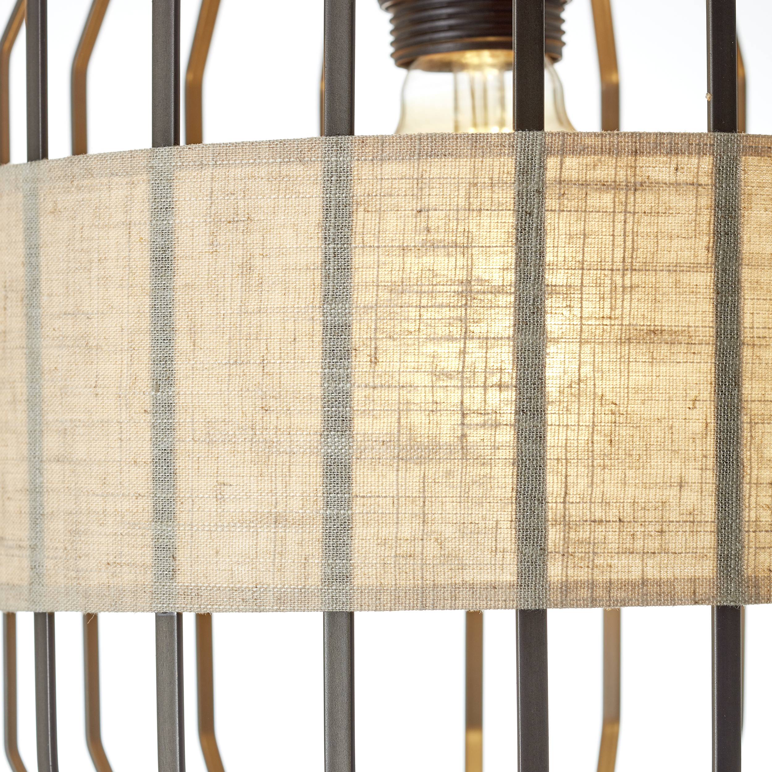 Lampe mit Stoffschirm in geometrischem Metallkäfig, sanft leuchtend.