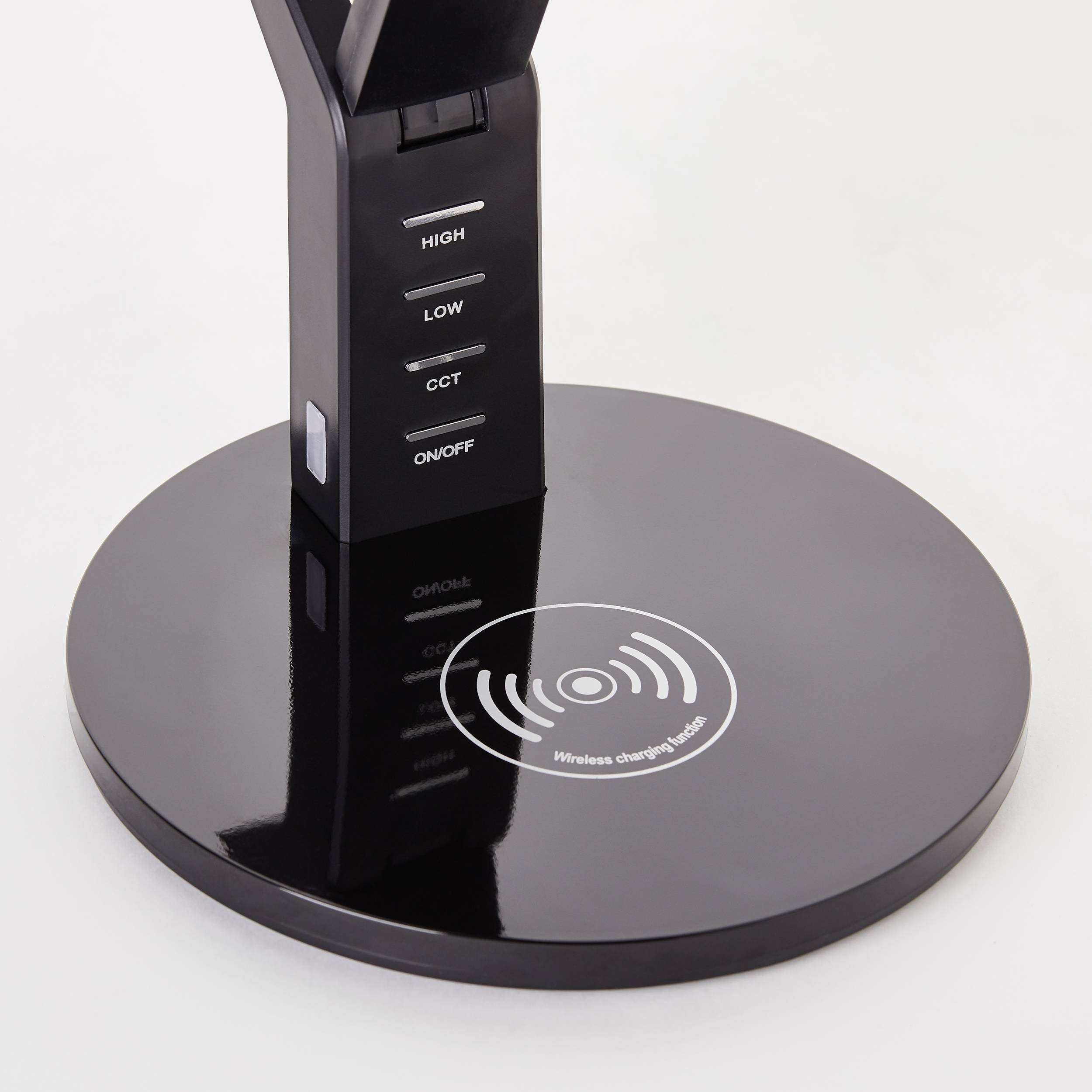 Eine schwarze Tischlampe mit kabelloser Ladefunktion auf der Basis, Tasten für 'High', 'Low', 'CCT' und 'On/Off' am Ständer.