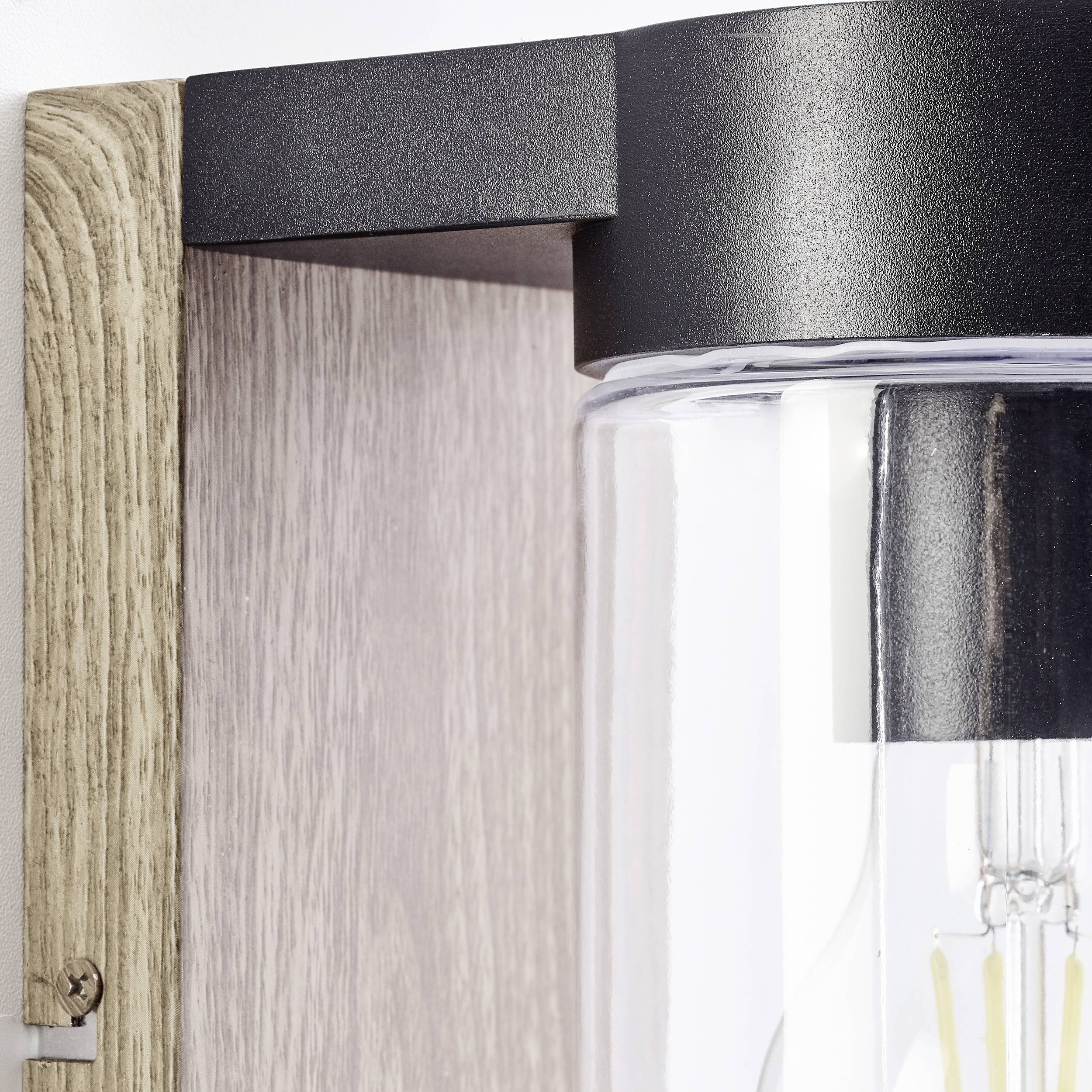 Nahaufnahme einer modernen Wandleuchte mit Holz- und Metallelementen. Eine Glühbirne ist hinter klarem Glas sichtbar.