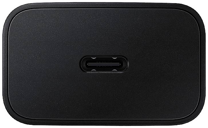 Ein schwarzer, rechteckiger Adapter mit einem USB-C-Anschluss in der Mitte. Der Adapter hat abgerundete Ecken.