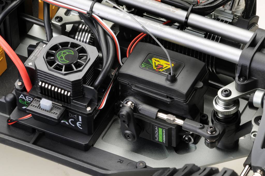 Nahaufnahme eines Modellauto-Innenraums mit Servomotor und Kühlgebläse. Kabel sind verbunden, sichtbare technische Details.