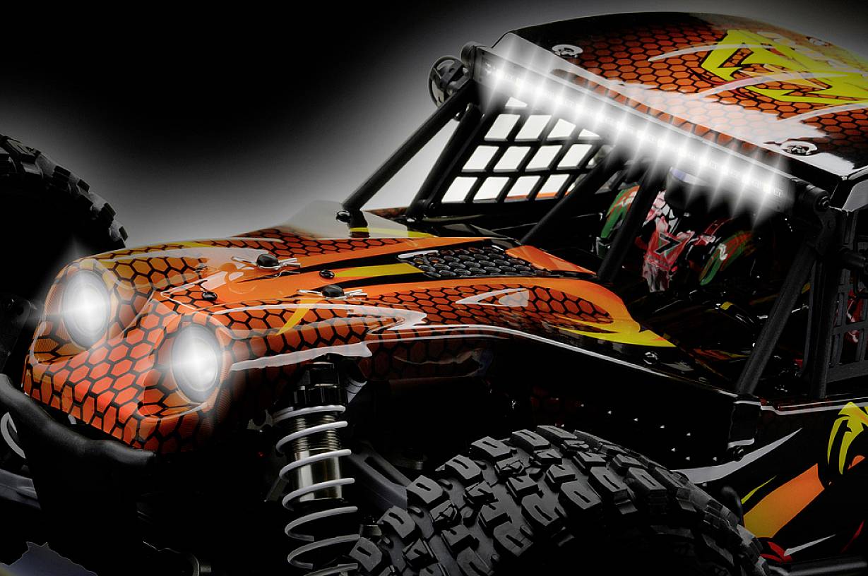 Ferngesteuertes Auto in Nahaufnahme, orange-schwarzes Design mit angedeuteten Scheinwerfern und LED-Leiste, Offroad-Reifen.