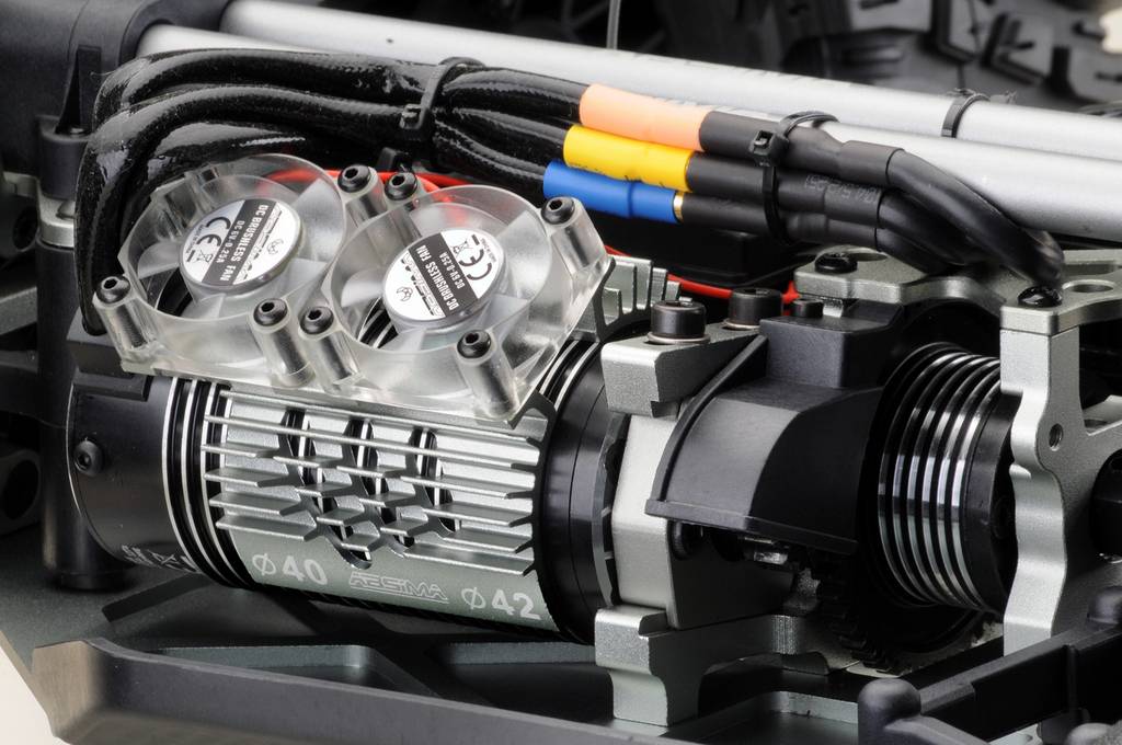 Nahaufnahme eines mechanischen Teils mit drei Lüftern und farbigen Kabeln. Es scheint Teil eines größeren Maschinenmodells zu sein.