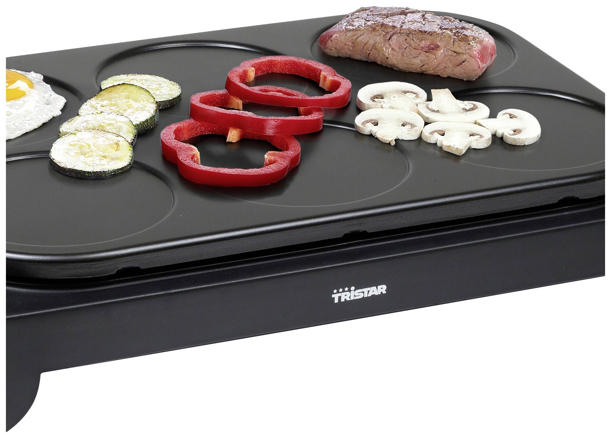 Ein Grill mit Zucchinischeiben, Paprikaringen, Pilzen, einem Rindersteak und einem Spiegelei. Ideal zum gleichzeitigen Braten verschiedener Zutaten.