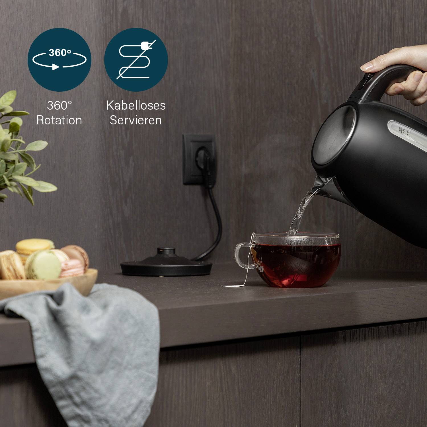 Wasserkocher füllt Tasse mit Tee. Aufschrift zeigt 360° Drehung und kabelloses Servieren. Obst und Brot auf der Arbeitsplatte.