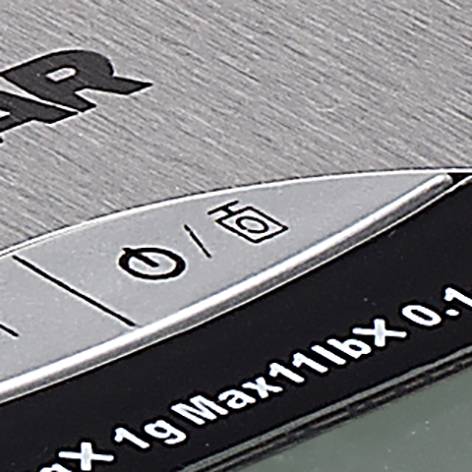 Teil einer digitalen Küchenwaage mit Bedientasten und einem Abschnitt der Gewichtsanzeige.