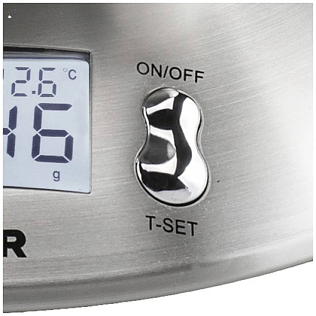 Nahaufnahme einer digitalen Küchenwaage mit silbernem Gehäuse. Display zeigt Temperatur in Grad Celsius und Gewicht in Gramm. Schalter für Ein/Aus und T-Set vorhanden.