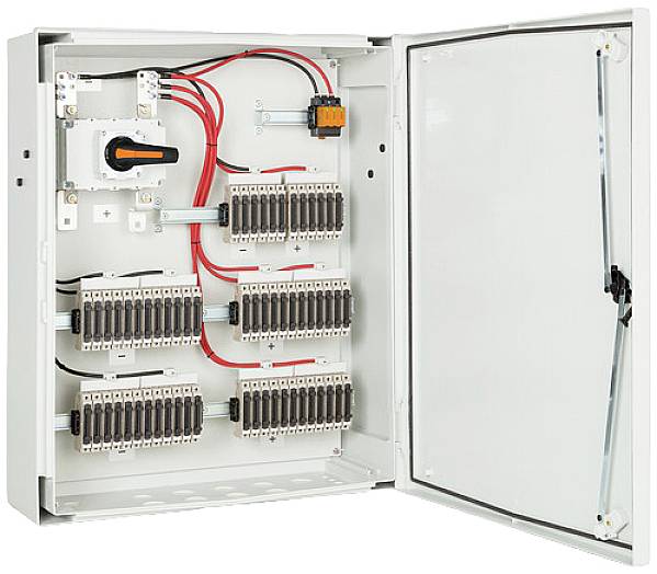 Geöffneter Verteilerkasten mit mehreren Sicherungsreihen und Kabelverbindungen. Links befindet sich ein Hauptschalter.