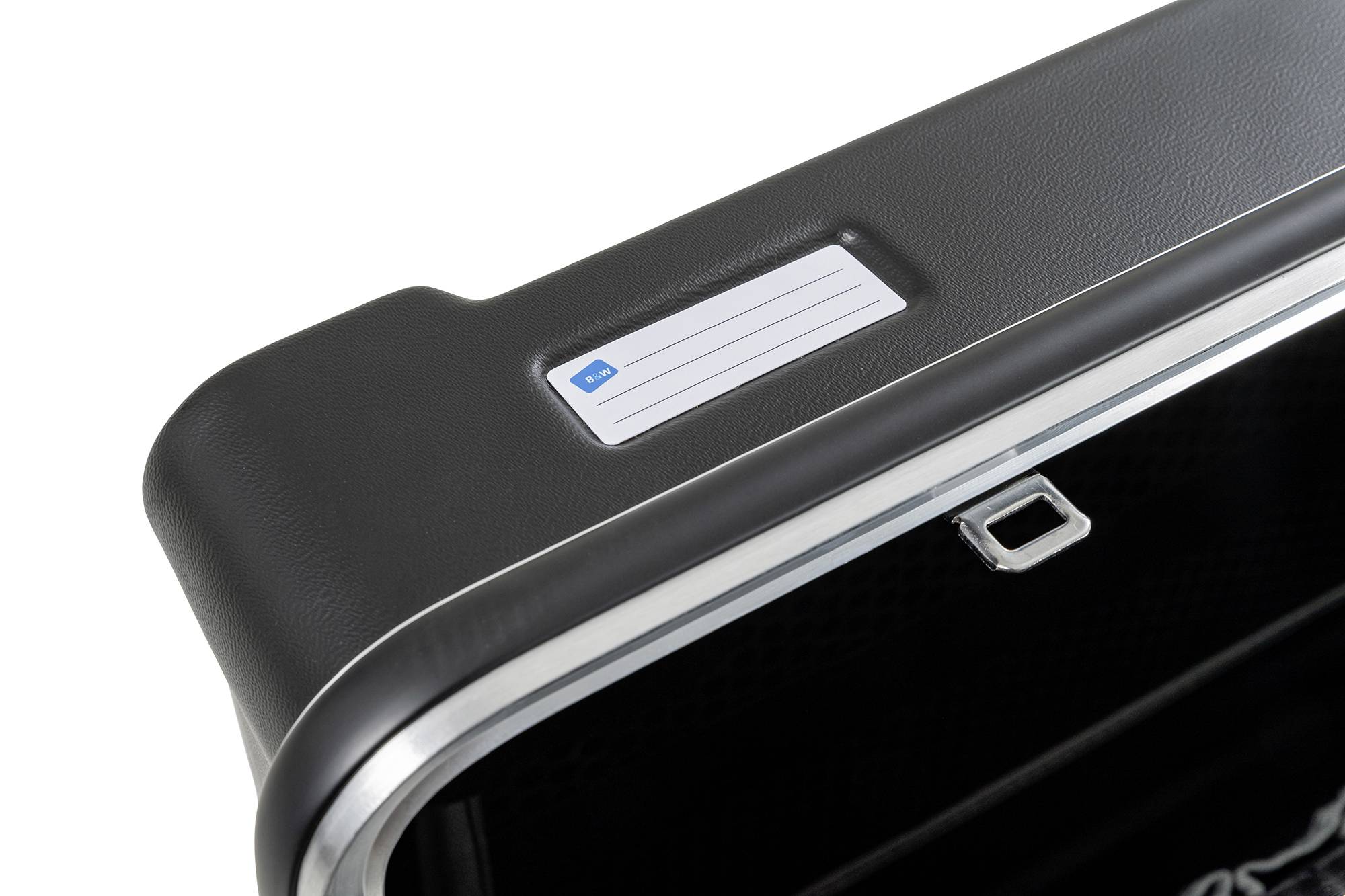 Ein schwarzer Koffer mit einem weißen Namensschild auf der Oberseite. Der Koffer hat einen silbernen Rand und einen kleinen Verschluss.