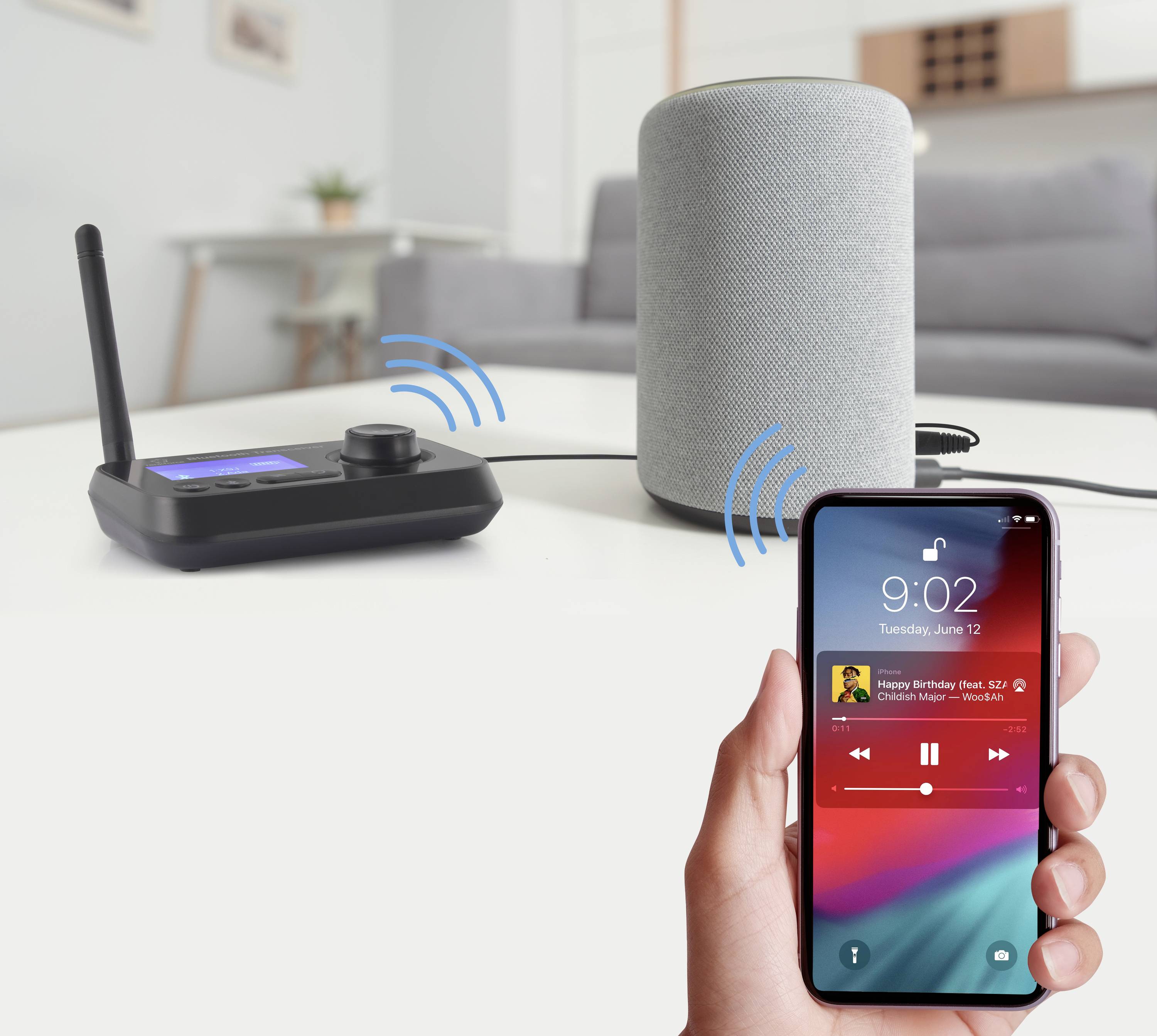 Eine Person hält ein Smartphone, das Bluetooth-Verbindung anzeigt. Im Hintergrund ein Lautsprecher und ein drahtloser Musikempfänger.