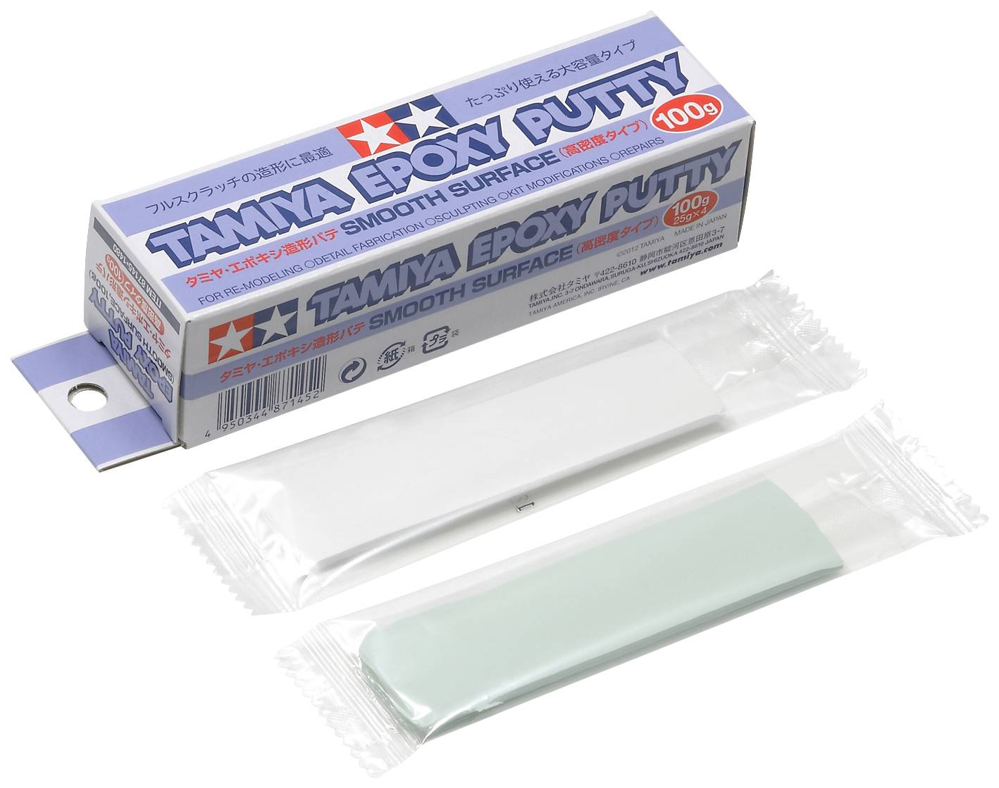 Zwei Päckchen Tamiya Epoxy Putty in Weiß und Grau liegen vor der Verpackung. Die Aufschrift auf der Schachtel lautet 'Tamiya Epoxy Putty'.