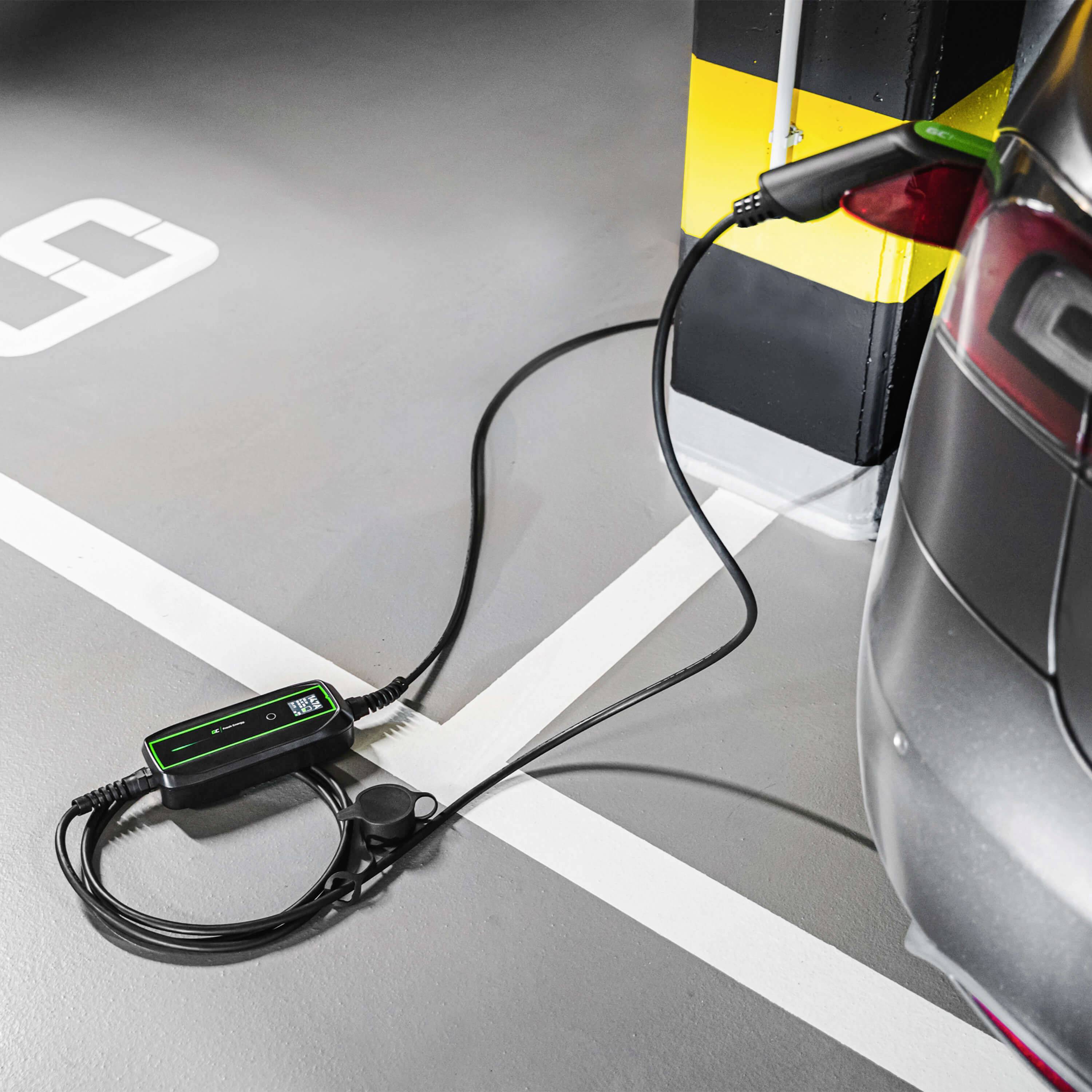 Ein Elektroauto wird in einer Garage an einer Ladestation aufgeladen. Ein Kabel verbindet das Auto mit der Ladestation an einer gelb-schwarz markierten Stange.