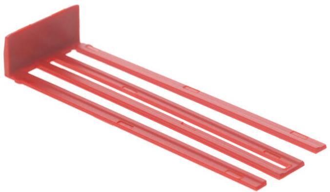 Ein rotes Kunststoffwerkzeug mit rechteckiger Basis und drei langen Zinken, möglicherweise zum Ausrichten oder Abstanden in einem Bau- oder DIY-Kontext verwendet.