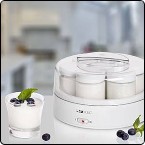 Elektrischer Joghurtbereiter mit vier Gläsern im Vordergrund. Ein Glas Joghurt mit Blaubeeren steht daneben als Serviervorschlag.