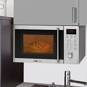 Eine Edelstahlmikrowelle in einer Küchenzeile, mit digitalem Display und einem Gericht im Inneren.