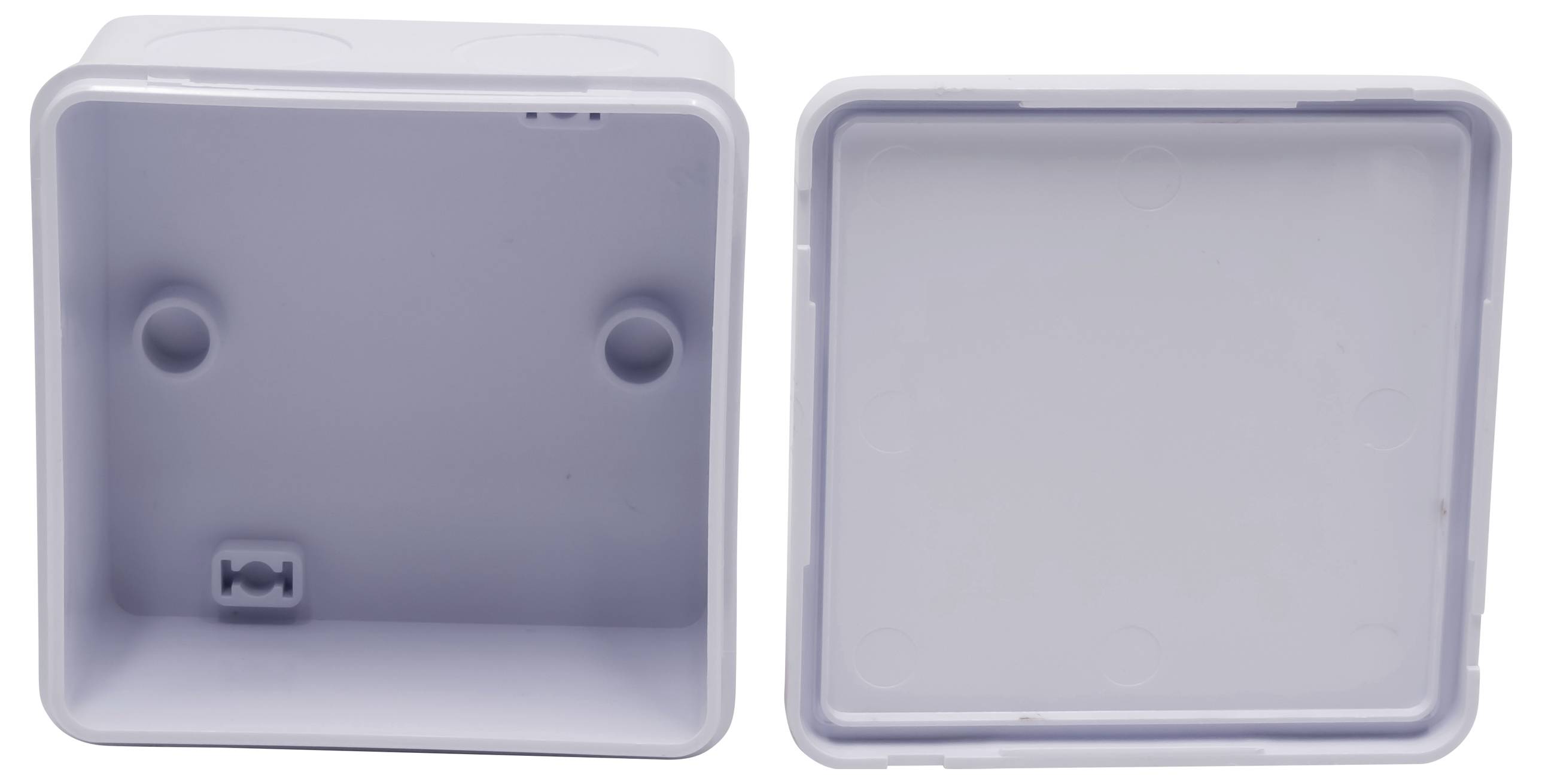 Eine graue Kunststoffdose, bestehend aus zwei Teilen, einem Boden und einem Deckel. Der Boden hat zwei zentral platzierte Befestigungspunkte.