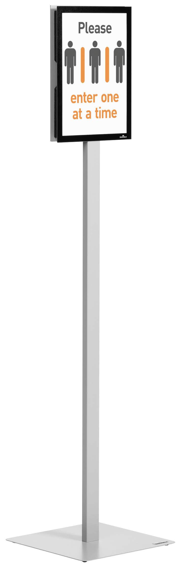 Stehendes Schild zeigt: 'Please enter one at a time' mit Symbolen von Personen. Es weist auf einzelnem Eintritt hin.