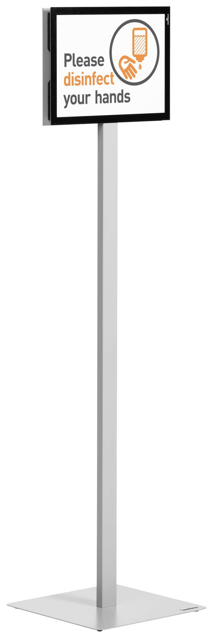 Schild mit der Aufforderung 'Please disinfect your hands' und einem Bild von einer Hand mit einem Desinfektionsmittel. Steht auf einem Ständer.