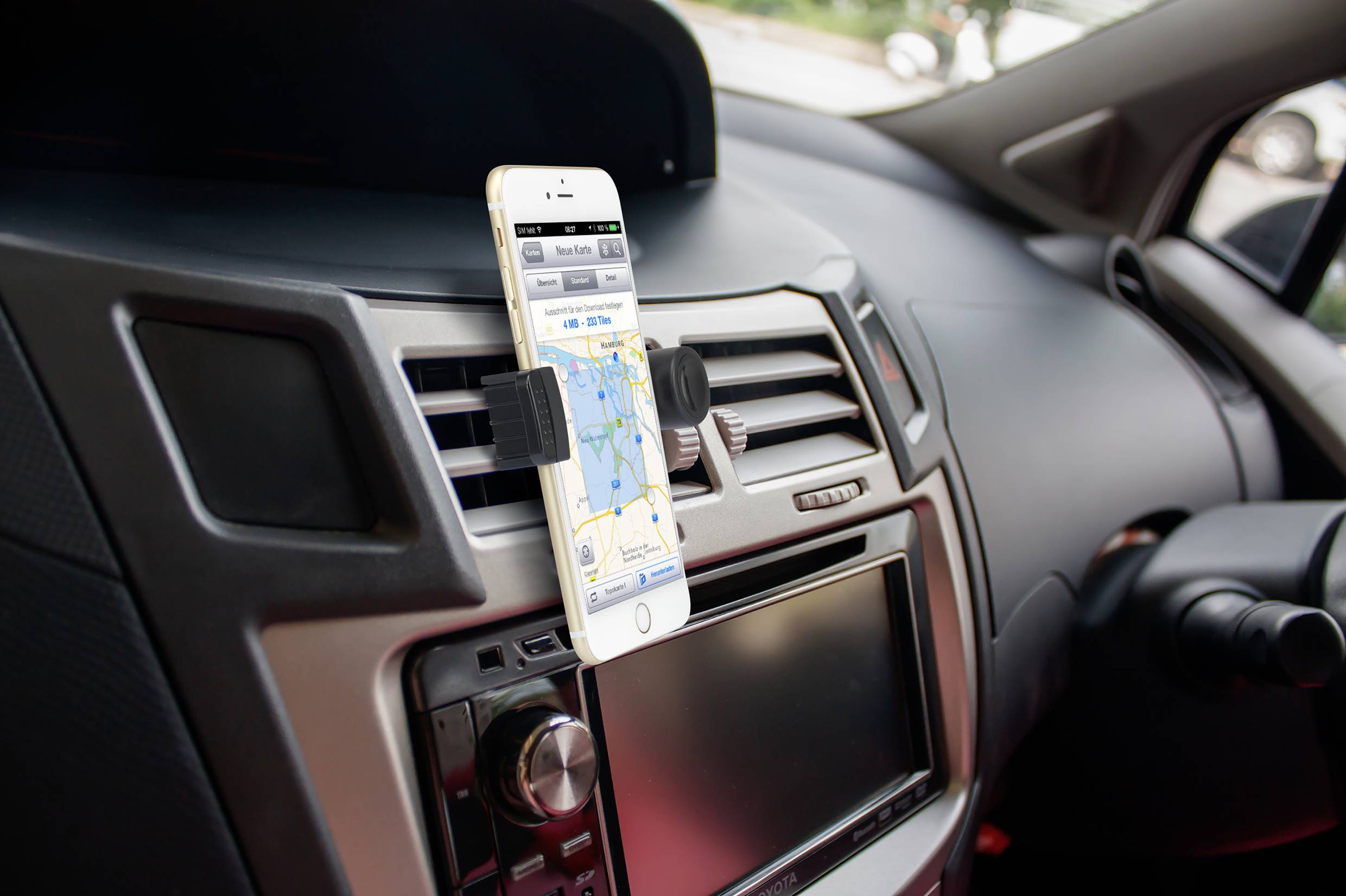 Smartphone-Halterung im Auto zeigt eine Navigations-App mit einer Straßenkarte auf dem Bildschirm.