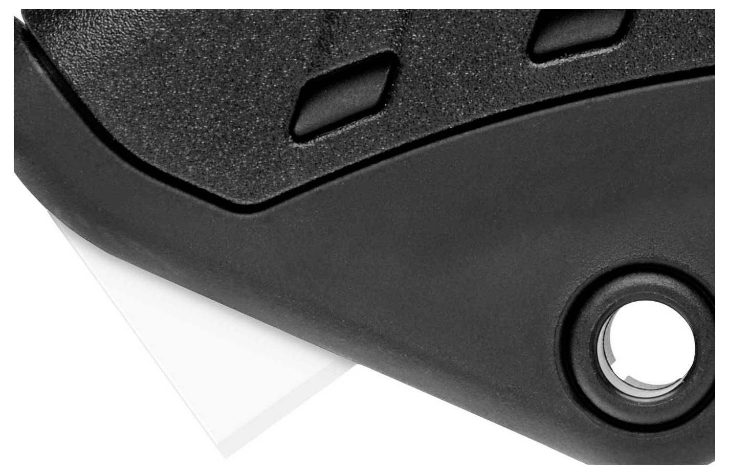 Schwarzer Kunststoff mit Loch und Teil eines weißen Objekts darunter.