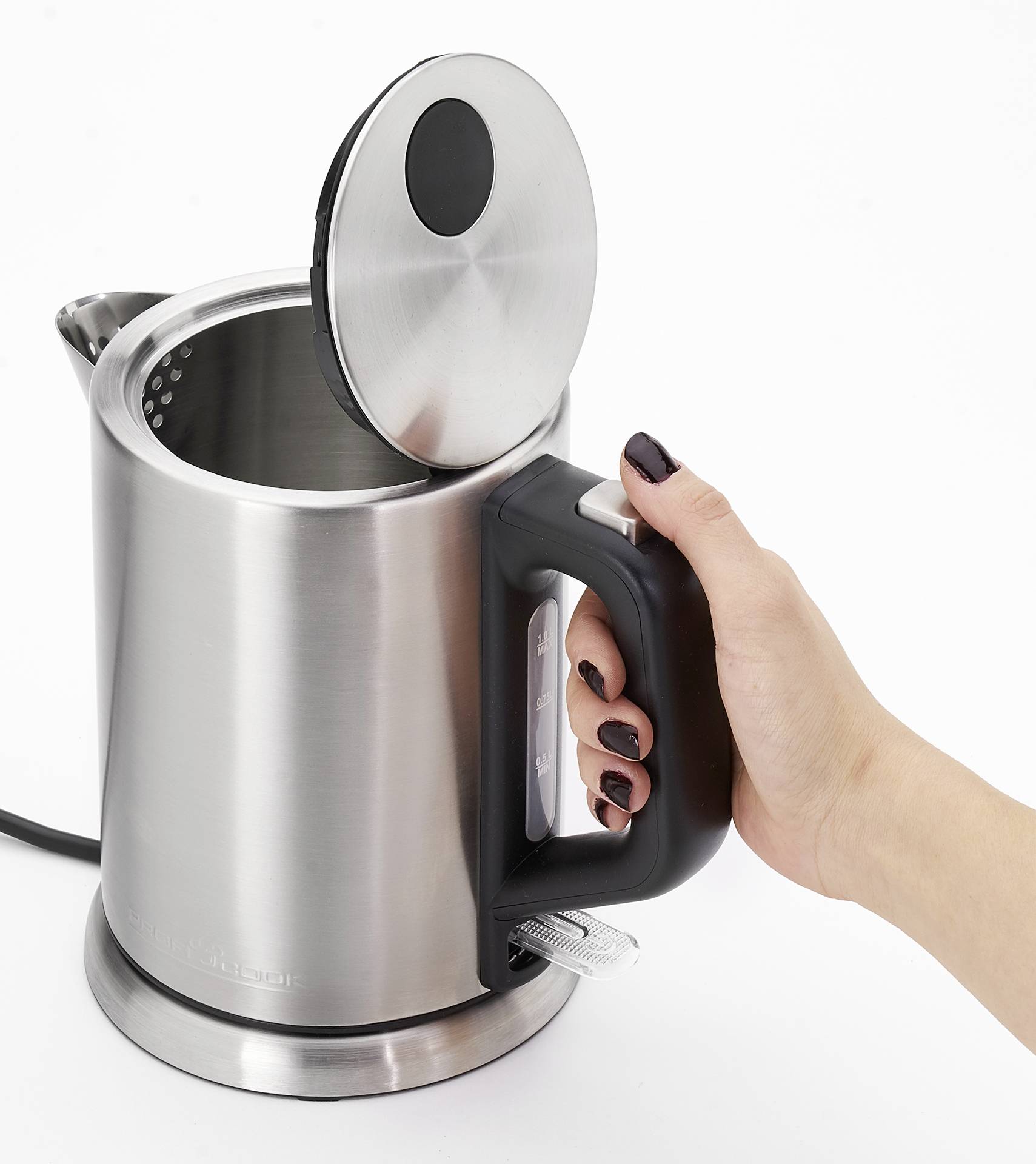 Eine Hand hält den Griff eines offenen, silbernen Wasserkochers mit schwarzem Deckel und sichtbarem Innenraum.