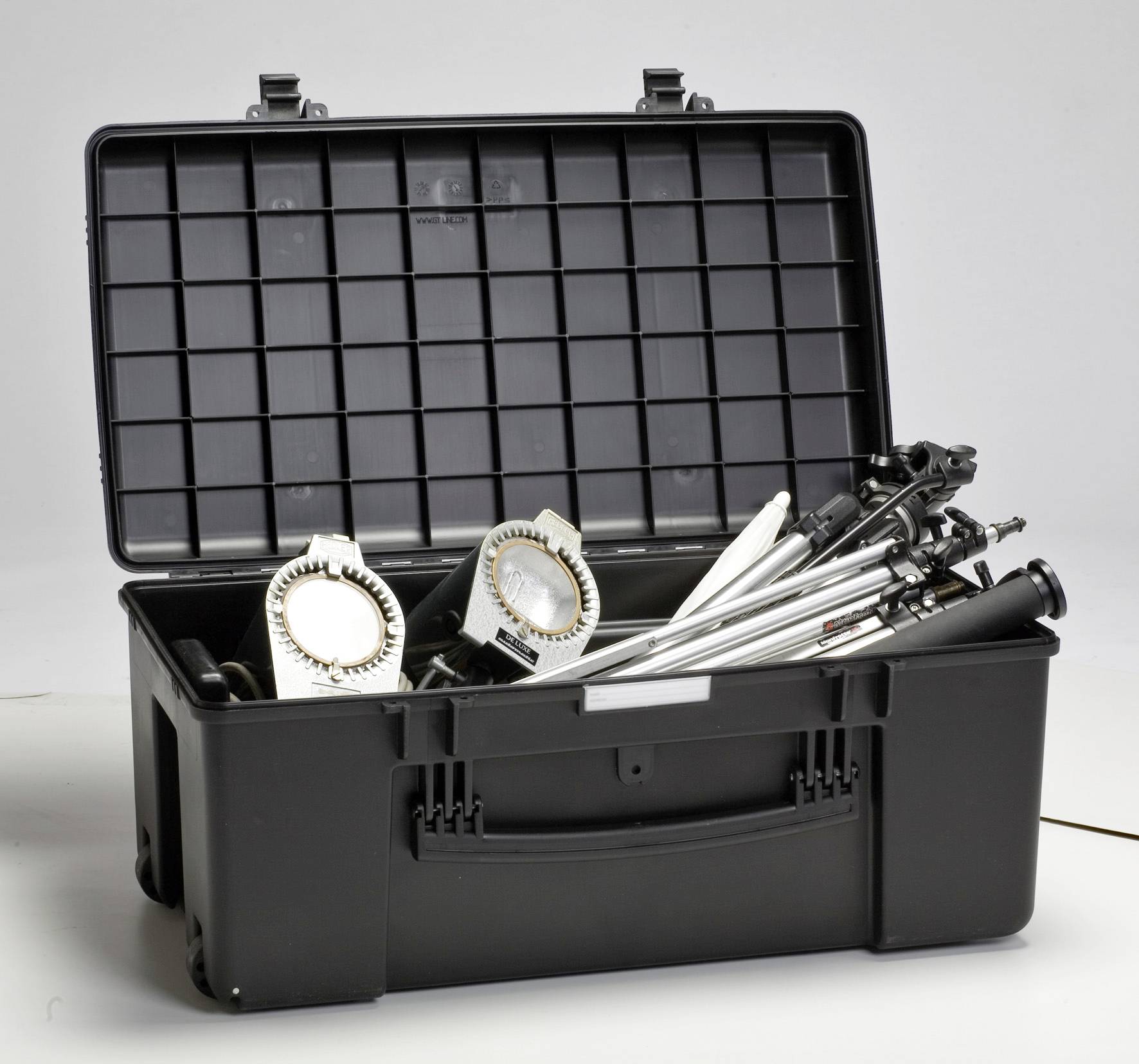 Ein offener schwarzer Koffer zeigt zwei Studiolampen und zusammengeklappte Stative. Sie scheinen für Fotografie oder Videografie gedacht zu sein.