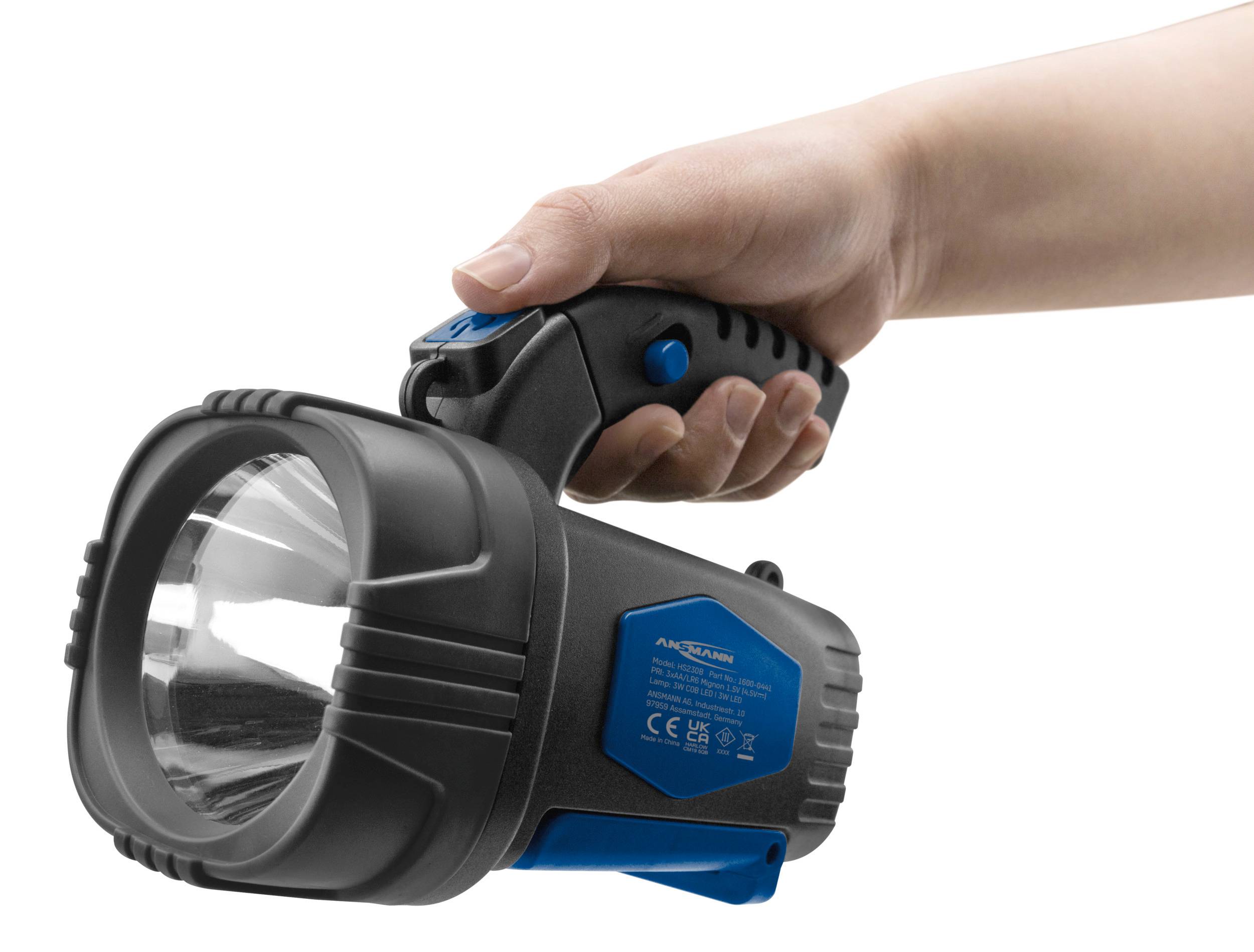 Hand hält eine schwarze und blaue Taschenlampe mit großen Reflektor.