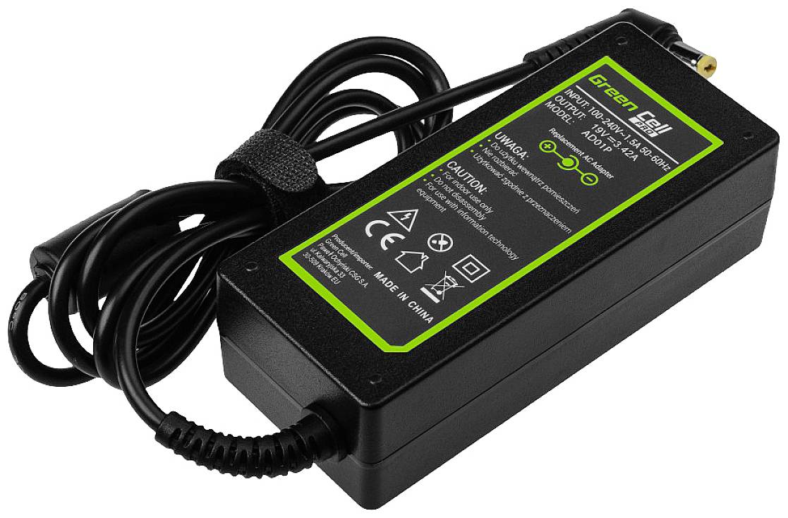 Schwarzes Laptop-Ladegerät mit grünem Aufkleber auf der Oberseite mit technischen Informationen und Symbolen, CE-Kennzeichnung sichtbar.